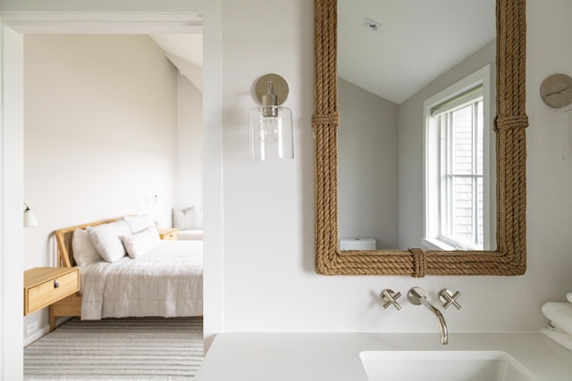 bedroom with sink and vaulted ceiling