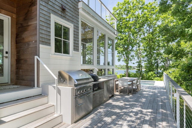 wooden terrace with exterior kitchen and a grill