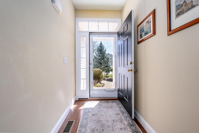 entryway featuring wood finished floors, visible vents, and baseboards
