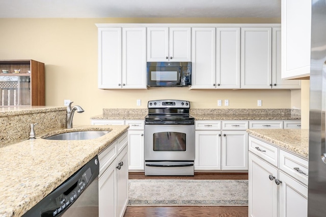 kitchen featuring light stone countertops, appliances with stainless steel finishes, white cabinets, dark wood-style flooring, and a sink