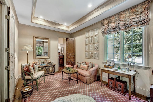 living area featuring a tray ceiling and ornamental molding