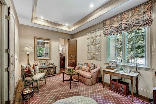 living area featuring a tray ceiling and ornamental molding