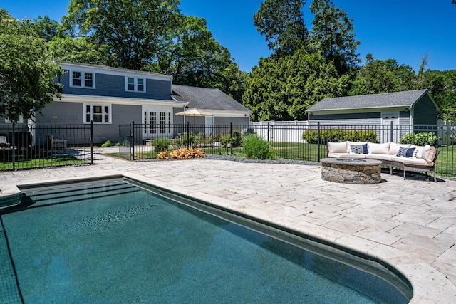 view of swimming pool featuring a patio area and an outdoor living space with a fire pit