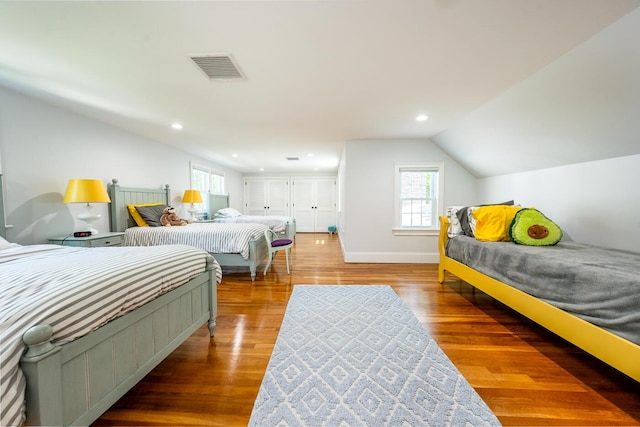 bedroom featuring hardwood / wood-style floors and lofted ceiling