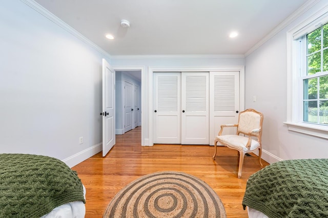 living area with a healthy amount of sunlight, light hardwood / wood-style flooring, and crown molding