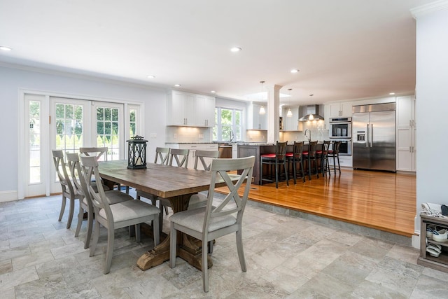 dining space with sink and ornamental molding