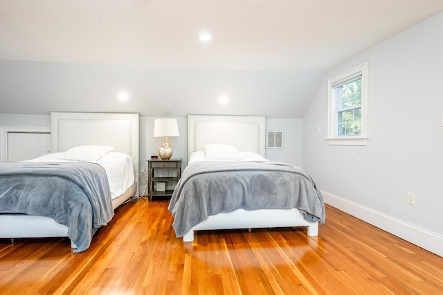 bedroom with light hardwood / wood-style floors and vaulted ceiling