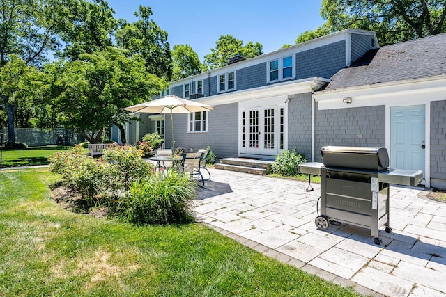 back of property with a yard, french doors, and a patio