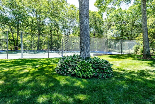 view of tennis court with a lawn