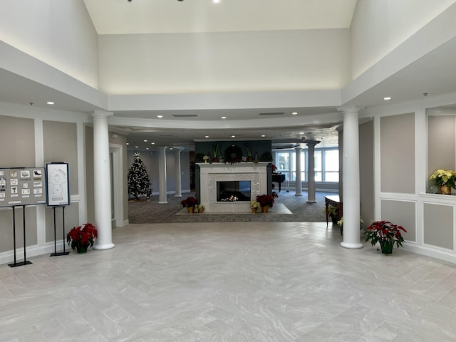 unfurnished living room featuring decorative columns