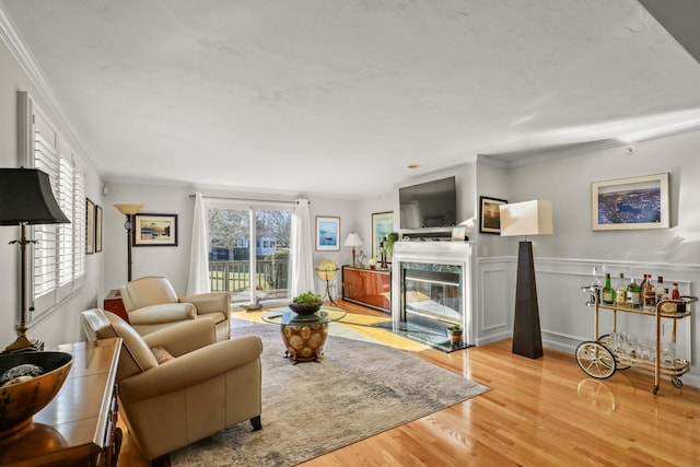 living room with crown molding, plenty of natural light, and light wood-type flooring