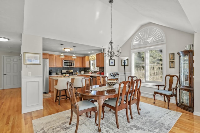 dining room with light wood-type flooring and lofted ceiling