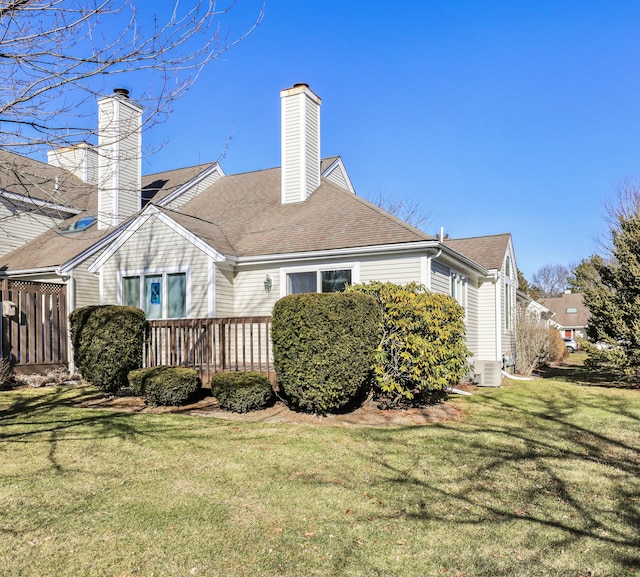 back of property with a wooden deck and a lawn