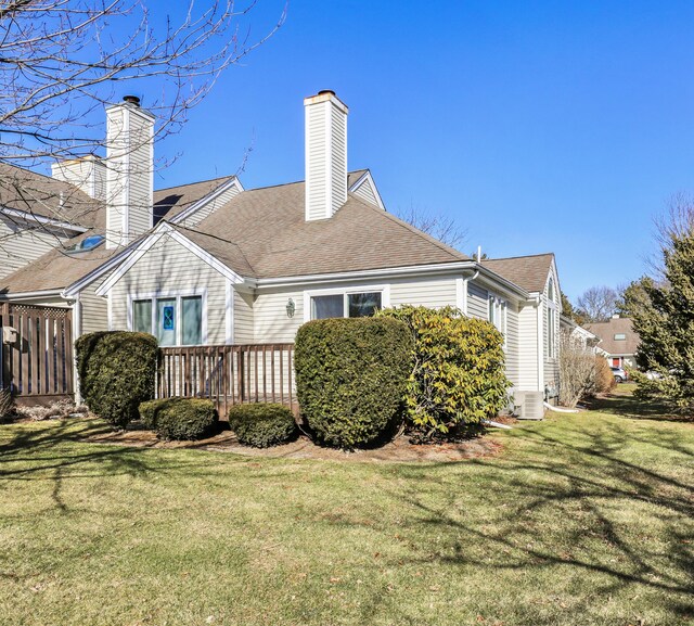 back of property with a wooden deck and a lawn