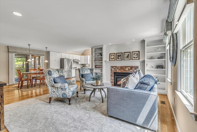 26 Sandy Meadow Way, Eastham, MA 02642 - living area with light wood-type flooring, a brick fireplace, and recessed lighting