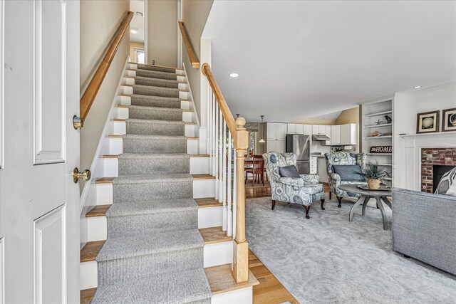 26 Sandy Meadow Way, Eastham, MA 02642 - stairway featuring wood finished floors, a brick fireplace, and recessed lighting