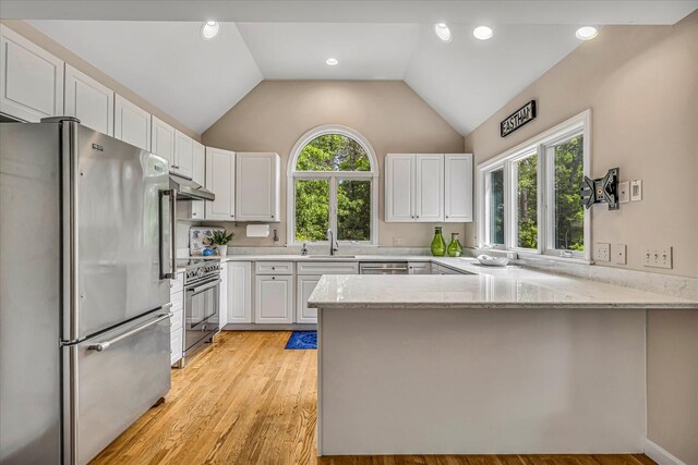 26 Sandy Meadow Way, Eastham, MA 02642 - kitchen with stainless steel appliances, a peninsula, under cabinet range hood, white cabinets, and lofted ceiling
