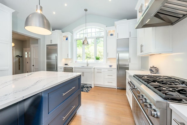 585 Santuit Rd, Cotuit, MA 02635 - kitchen featuring ventilation hood, premium appliances, white cabinetry, blue cabinets, and hanging light fixtures