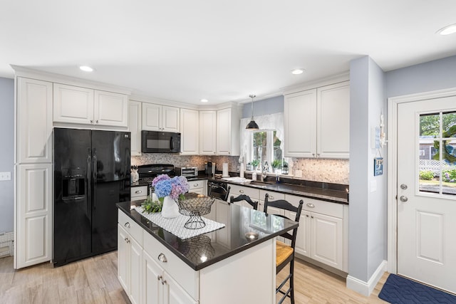 10 Stanley Rd, Mashpee, MA 02649 - kitchen with black appliances, healthy amount of natural light, light wood-type flooring, a center island, and recessed lighting