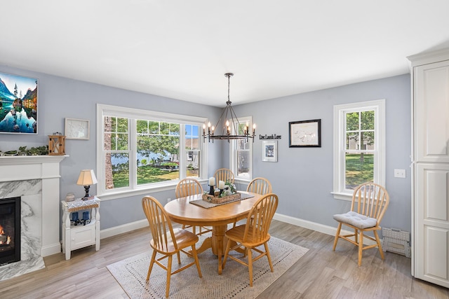 10 Stanley Rd, Mashpee, MA 02649 - dining room with a chandelier, plenty of natural light, light wood-type flooring, and a high end fireplace