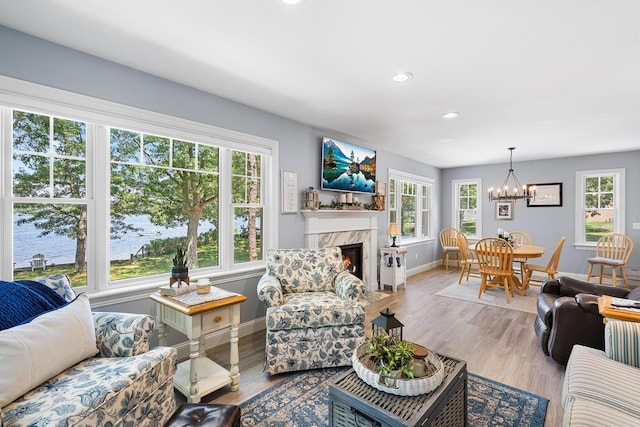 10 Stanley Rd, Mashpee, MA 02649 - living room with a chandelier, a premium fireplace, recessed lighting, wood finished floors, and a water view