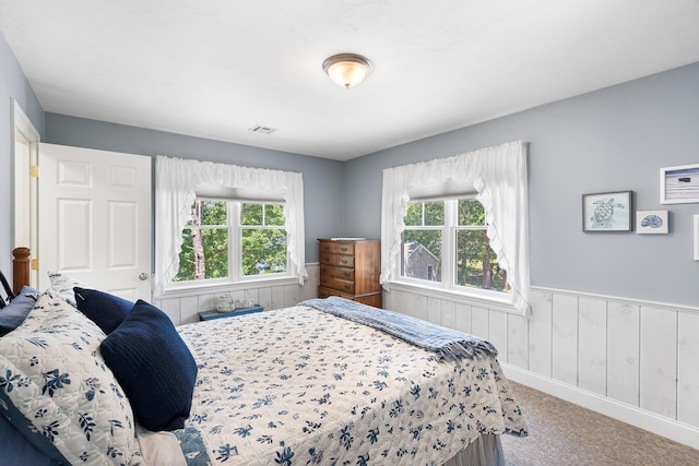 10 Stanley Rd, Mashpee, MA 02649 - bedroom featuring multiple windows, a wainscoted wall, carpet floors, and wooden walls