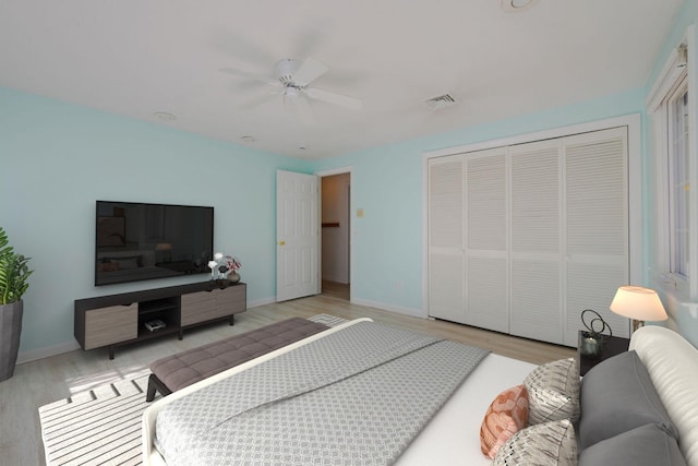 bedroom featuring ceiling fan, light hardwood / wood-style floors, and a closet