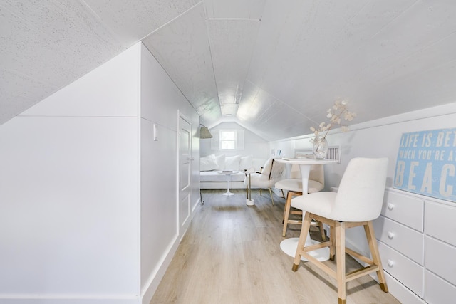 interior space with light hardwood / wood-style flooring and vaulted ceiling