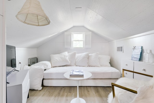 bedroom with light hardwood / wood-style flooring and lofted ceiling