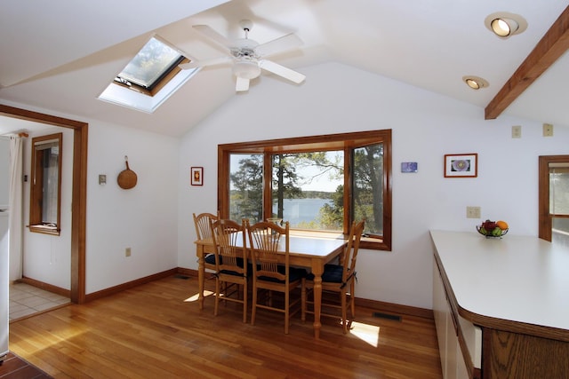 21 High Point Dr, Brewster, MA 02631 - dining room with light wood-style flooring, a skylight, vaulted ceiling, ceiling fan, and baseboards
