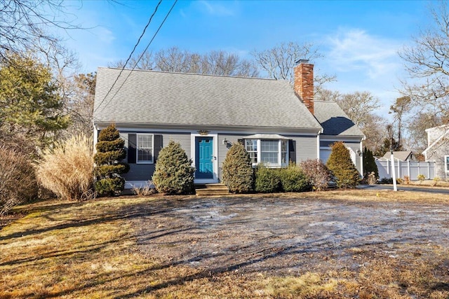 cape cod-style house with a shingled roof and a chimney