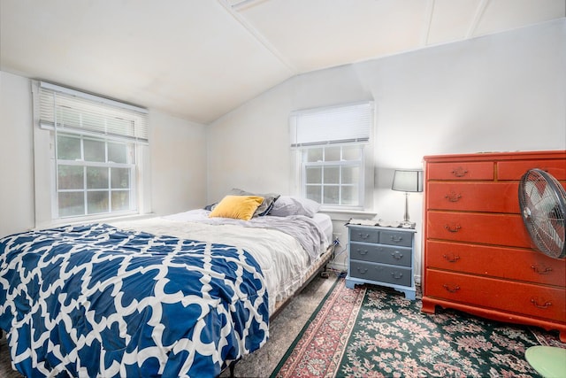 bedroom with dark colored carpet and lofted ceiling