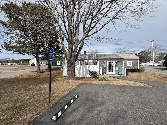 view of front of home with a shingled roof and fence