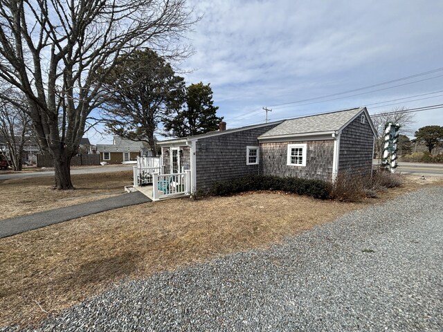 view of front of home with a shingled roof and a chimney