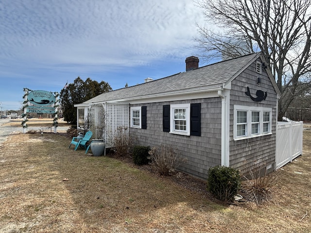 view of property exterior featuring a chimney and roof with shingles