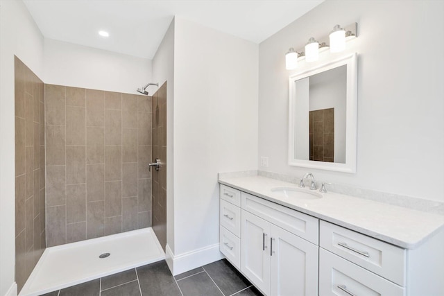 bathroom featuring a tile shower, tile patterned flooring, and vanity