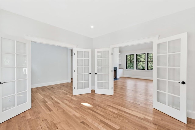 spare room featuring light wood-type flooring and french doors