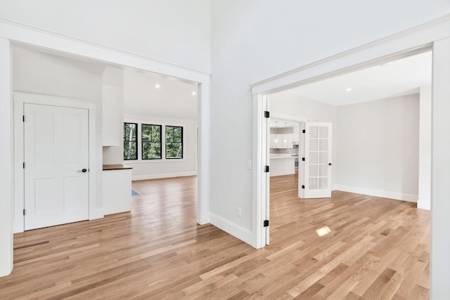 hallway featuring french doors and light wood-type flooring