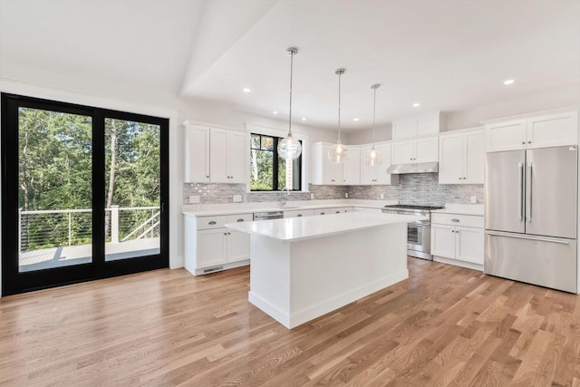 kitchen featuring light hardwood / wood-style flooring, pendant lighting, white cabinetry, a center island, and stainless steel appliances