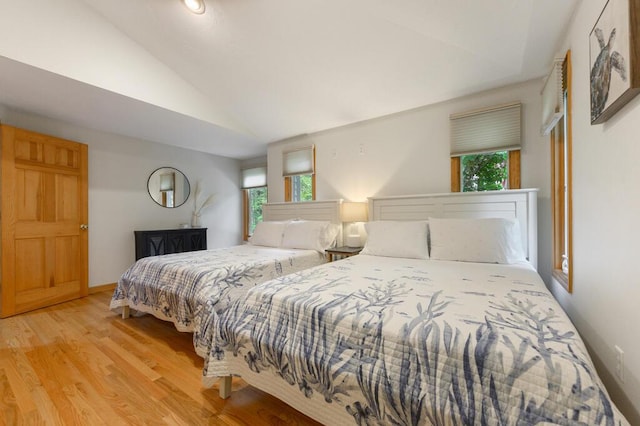 bedroom featuring light hardwood / wood-style floors and vaulted ceiling