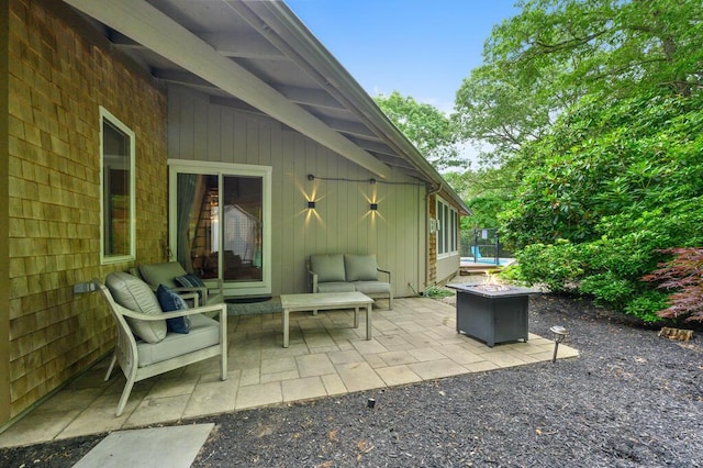 view of patio with an outdoor living space with a fire pit and a trampoline