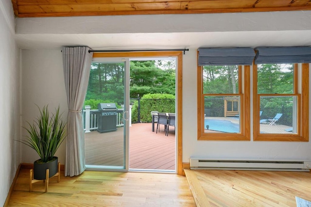 doorway to outside with light hardwood / wood-style flooring and a baseboard heating unit