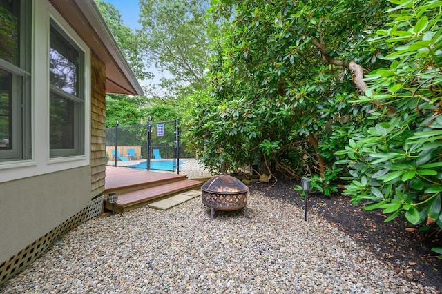 view of yard with a wooden deck and a fire pit