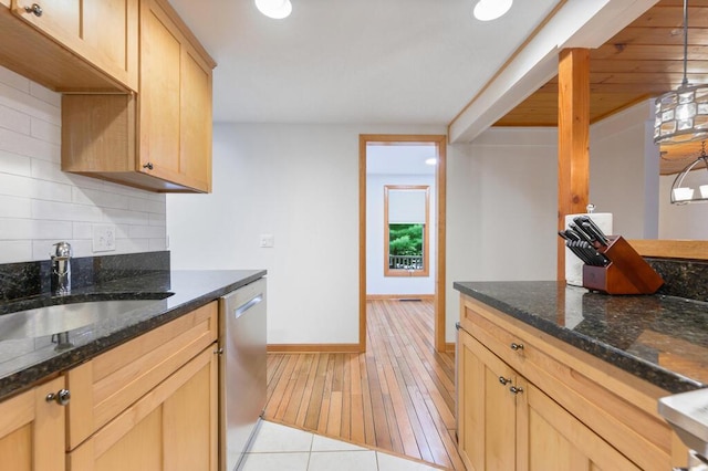 kitchen with light brown cabinets, dark stone countertops, sink, backsplash, and stainless steel dishwasher