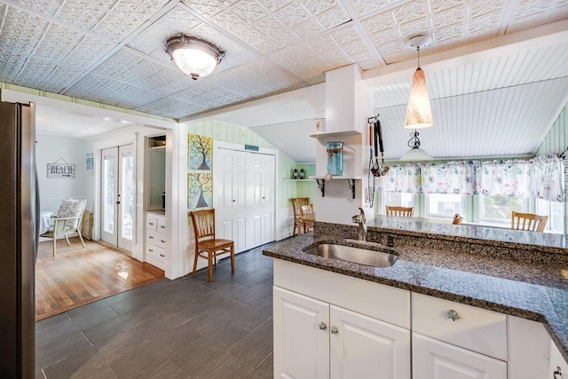 281 Gosnold St, Hyannis, MA 02601 - kitchen featuring a sink, freestanding refrigerator, white cabinets, dark stone countertops, and vaulted ceiling