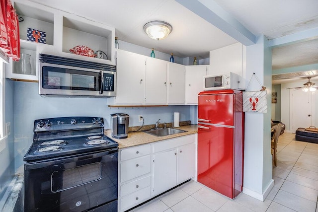 281 Gosnold St, Hyannis, MA 02601 - kitchen featuring black electric range, stainless steel microwave, a sink, freestanding refrigerator, and light tile patterned floors