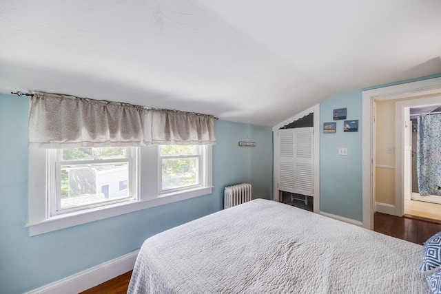 281 Gosnold St, Hyannis, MA 02601 - bedroom with radiator heating unit, vaulted ceiling, baseboards, multiple windows, and dark wood-type flooring