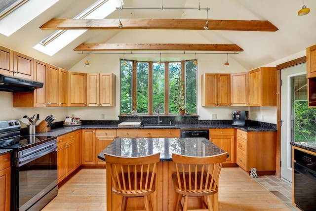 174 Middle Rd, Chilmark, MA 02535 - kitchen with black appliances, under cabinet range hood, a skylight, light wood-style floors, and a kitchen bar