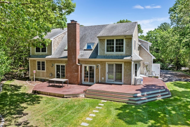 back of house with roof with shingles, a lawn, a chimney, and a wooden deck