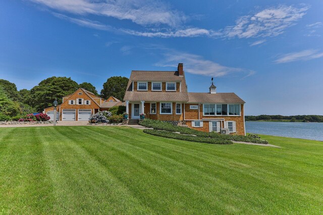 45 Seth Ln, South Yarmouth, MA 02664 - view of front of home with a chimney, a front lawn, a water view, and driveway